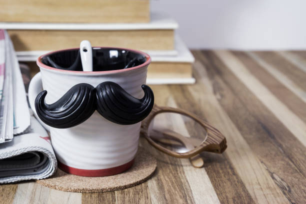 Cup with mustache on wooden table for fathers day concept