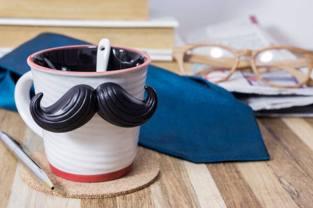 istock Cup with mustache on wooden table for fathers day concept 671403496