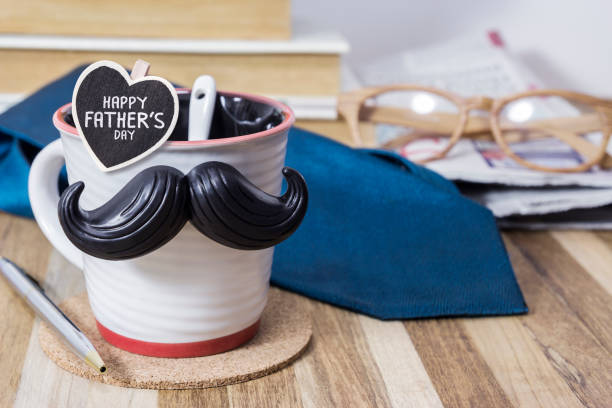 istock Cup with mustache on wooden table for fathers day concept 671403984