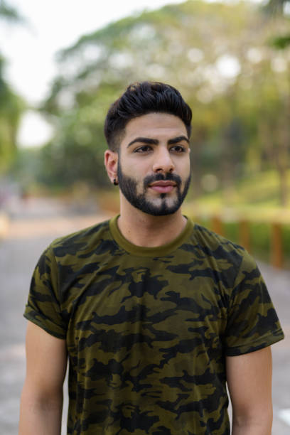 istock Young handsome Indian man thinking against quiet road in the park 671404882