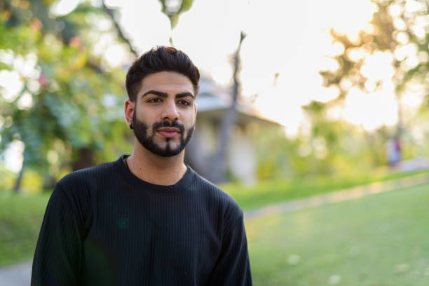 istock Young handsome Indian man thinking at the park 671405022