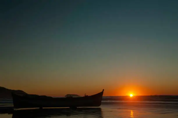 Dawn at Santinho Beach in Florianópolis, Santa Catarina. The fishing boat is prepared for another day of work of the fishermen going in search of schools of fish for their livelihood.