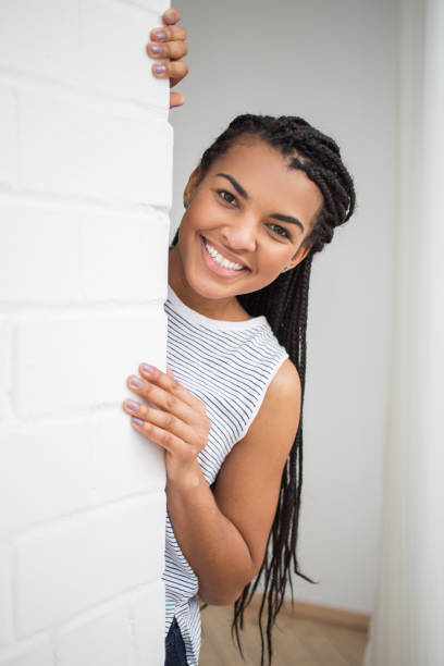 istock Happy Pretty Black Woman Peeping From Behind Wall 671416100