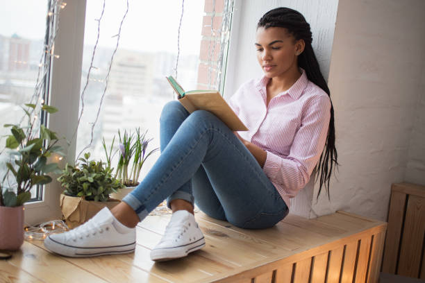 istock Concentrated African woman reading book 671418196