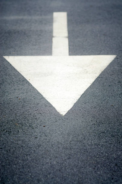 istock White painted direction arrow sign on the road 671419020