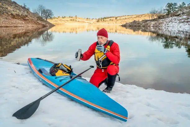 Hot tea break during winter paddling on stand up paddleboard in Colorado