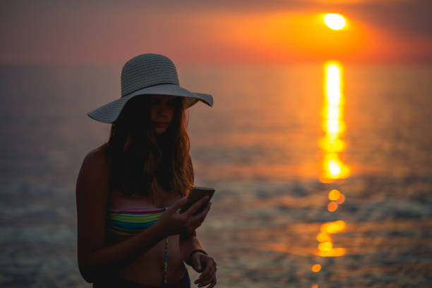 istock Cute girl on the beach watching the sunset 671425672