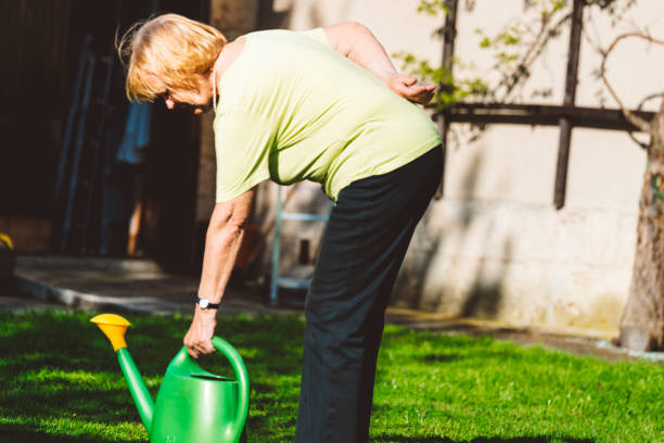 istock Senior woman watering flowers 671426036