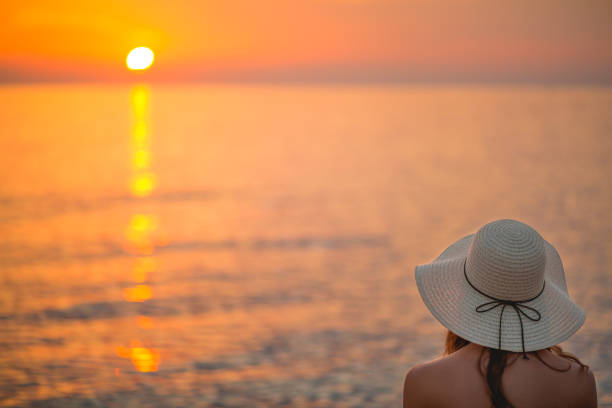 istock Cute girl on the beach watching the sunset 671426392