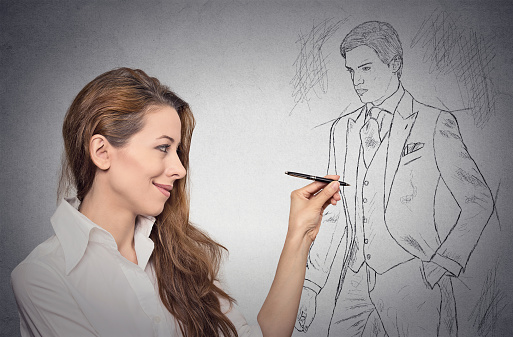 woman stylist drawing sketch of male model dressed in suit