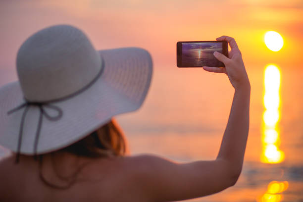 istock Cute girl photographing the sunset 671428632
