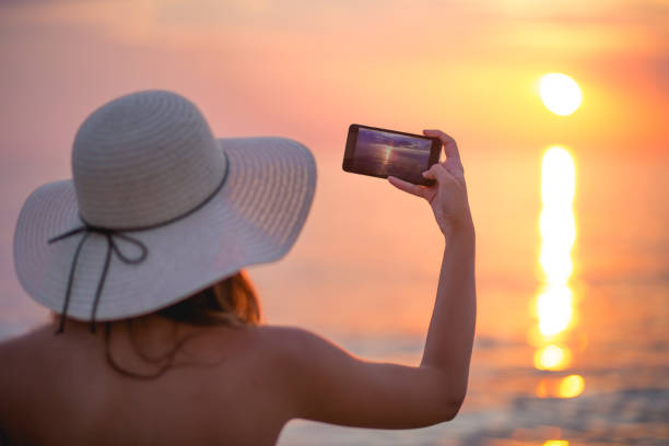 istock Cute girl photographing the sunset 671428662