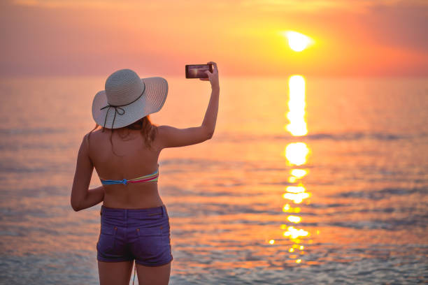 istock Cute girl photographing the sunset 671428868