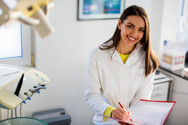 istock Beautiful woman dentist writing notes 671428876