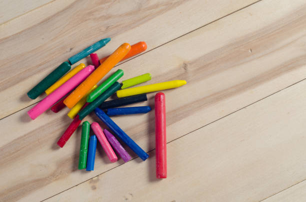istock Wax crayons and white paper on wooden background 671436966