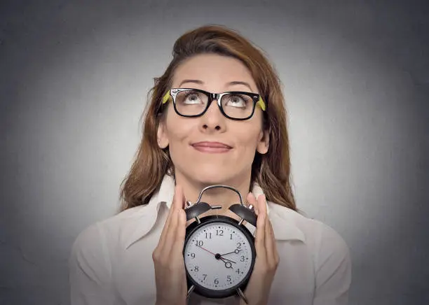 Photo of alarm-clock. headshot young excited business woman with alarm clock