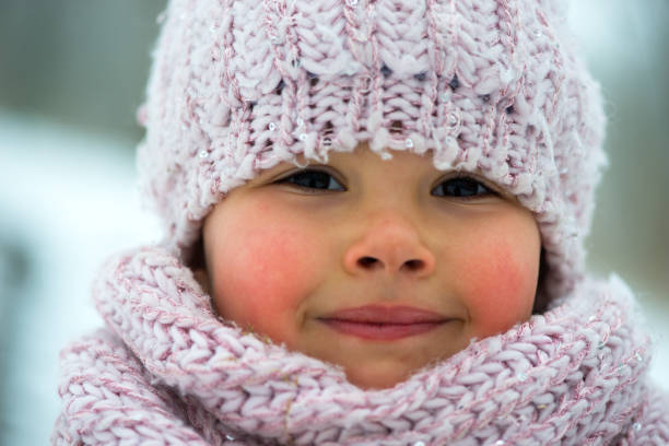 bambina nella stagione invernale con le guance rosse - guance rosa foto e immagini stock