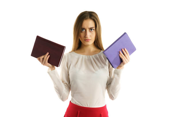 surious student girl with book in hands stock photo