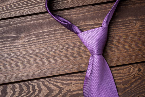 istock Purple necktie on wooden table 671451556