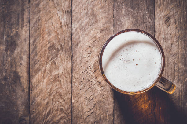 istock Mug of beer on an old wooden table 671452126