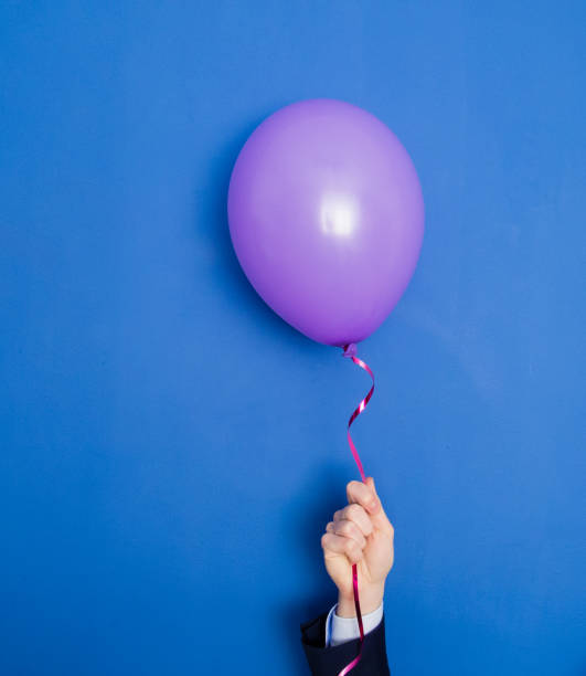 istock Hand in a suit holding flying up balloon. 671455086