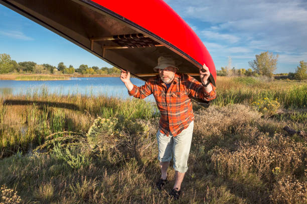 portaging canoe on a lake shore