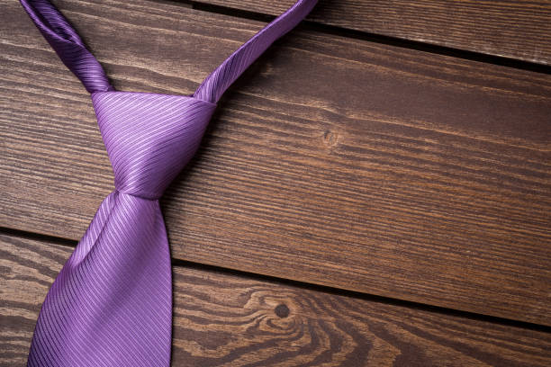 istock Purple necktie on wooden table 671458156
