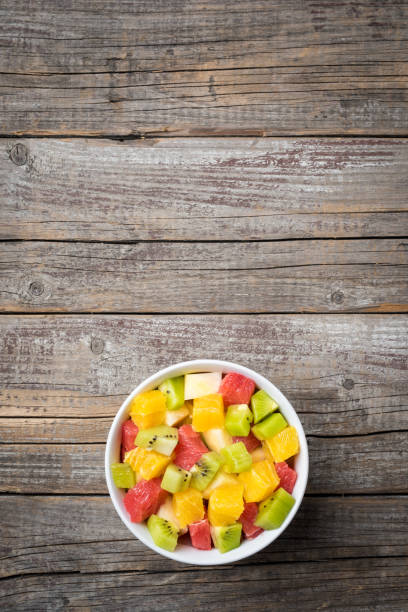 istock Fresh fruit salad on an old wooden background 671458294