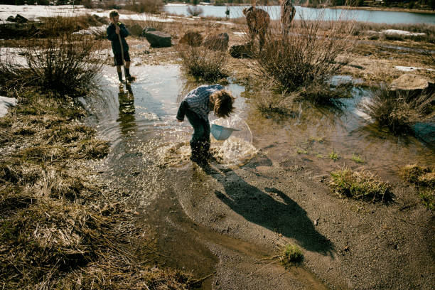 istock Child splashes in the mud with family 671458850