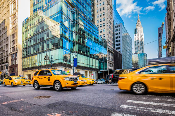 Yellow taxis on busy street in New York City Blurred motion of yellow taxis on busy city street. View of Chrysler Building and modern skyscrapers in New York City. Travel locations. manhattan new york city photos stock pictures, royalty-free photos & images