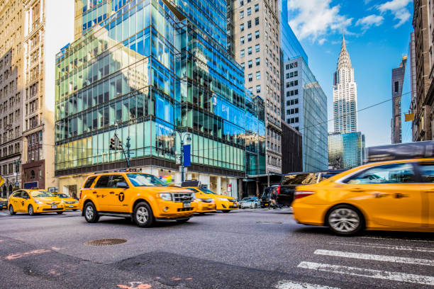 Yellow taxis on busy street in New York City Blurred motion of yellow taxis on busy city street. View of Chrysler Building and modern skyscrapers in New York City. Travel locations. midtown manhattan tourism new york city usa stock pictures, royalty-free photos & images