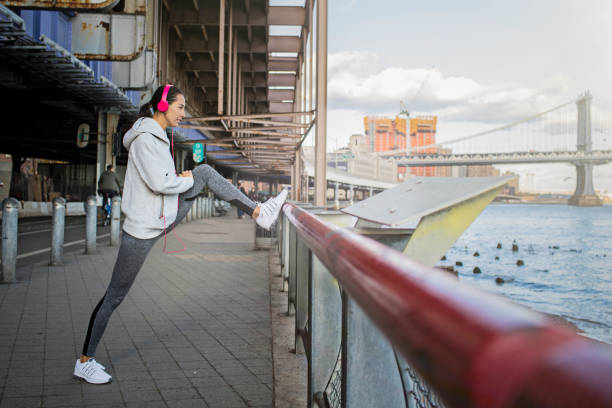 ストレッチ運動をしている決定された若い女性 - railing beautiful human leg people ストックフォトと画像