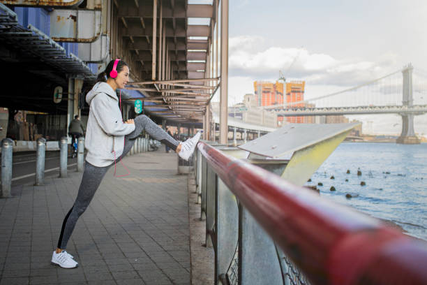 определенная молодая женщина делает упражнения на растяжку - east river audio стоковые фото и изображения