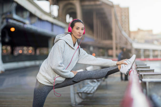 ストレッチ運動をしている決定された若い女性 - railing beautiful human leg people ストックフォトと画像