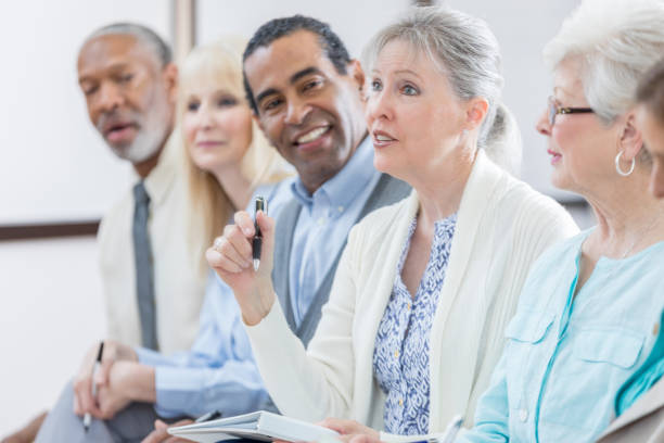 istock Confident senior woman asks question during seminar 671472916