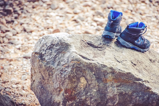 Drying Trekking Shoes on the Large Stone. Trail Hiking Concept Photo.