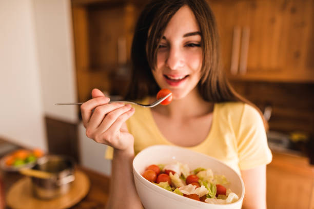 istock woman eating a vegetable 671492804