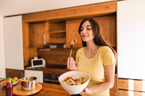 istock woman eating a vegetable 671492874