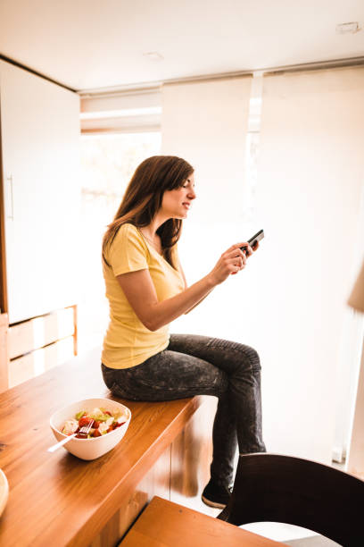 istock woman on the phone in the kitchen 671493274