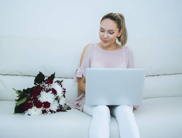 istock Woman holding flowers and working with laptop 671494400