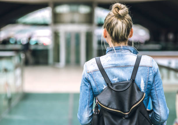 istock Young woman with backpack walking on the european streets 671494768