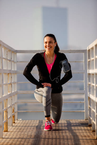 istock Smiling female warming up for running 671500116
