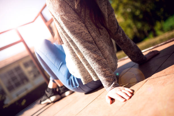 Young teenage girl sitting on the balcony, thinking, enjoying the sunshine and nice weather