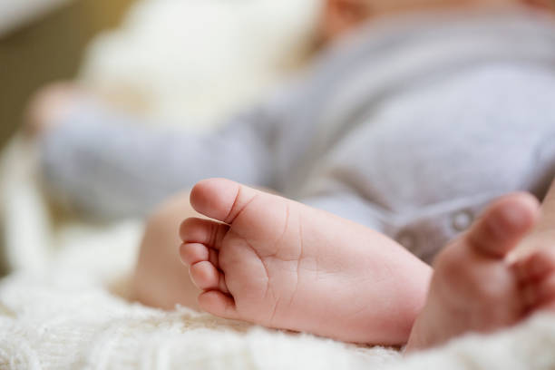 赤ちゃんの足の指 - simplicity innocence new life clothing ストックフォトと画像
