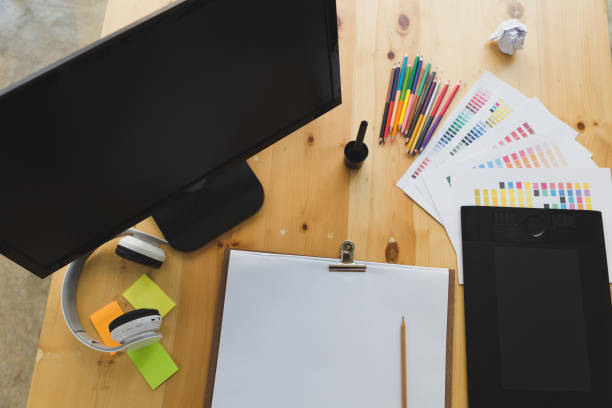 istock desk of graphic designer at work - digital tablet, computer screen, color swatch catalog samples for selection. Creativity Editor Ideas Concept 671504638