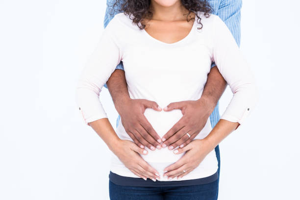 istock Midsection of couple with hands on belly 671508170