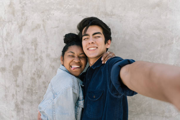 la coppia si prende un selfie divertente! - heterosexual couple foto e immagini stock