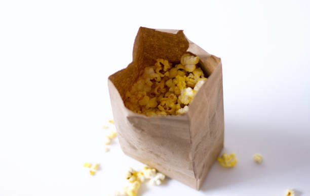 Popcorn in Brown Paper Bag, White Background, Copy Space