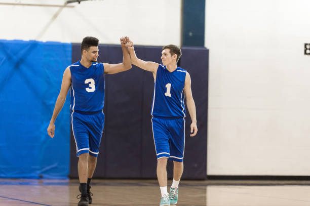 Boys high school basketball team: Boys high school basketball team: two teammates hi-five each other after game two men same clothes stock pictures, royalty-free photos & images