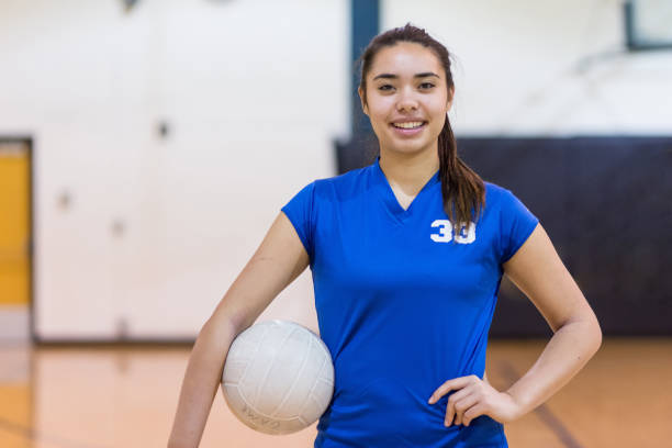 Girls high school volleyball team High school player poses with volleyball in gym before her game young volleyball girl stock pictures, royalty-free photos & images